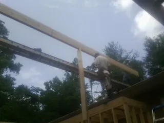 Carpenter setting a ridge beam over a new addition frame — Ice Dam Removal by Roofing Brothers in Rexburg