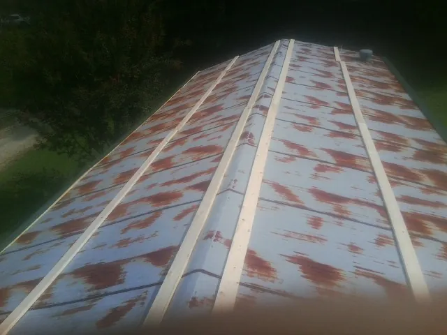 Rusted metal roof panels with new wood purlins before replacement — Storm Damage Roof Repair in Rexburg by Roofing Brothers