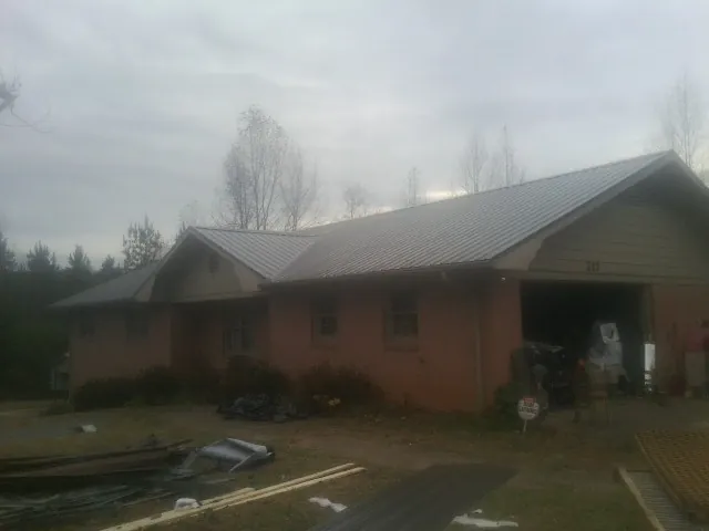 Gray metal roof on a stucco house with an attached garage in Rexburg