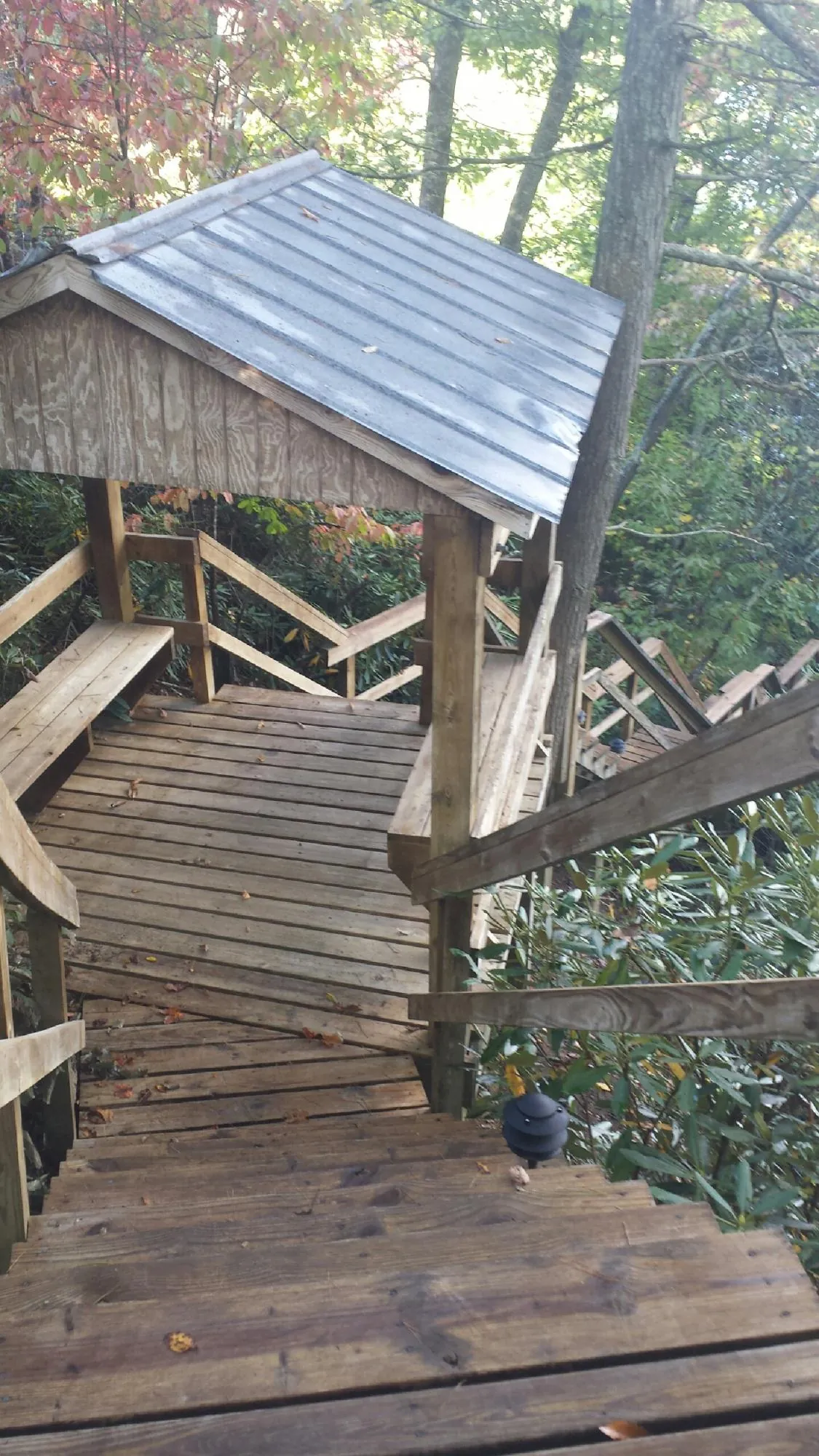 Metal roofed shelter over wooden steps on a wooded walkway — Skylight Repair & Installation work by our crew in Rexburg