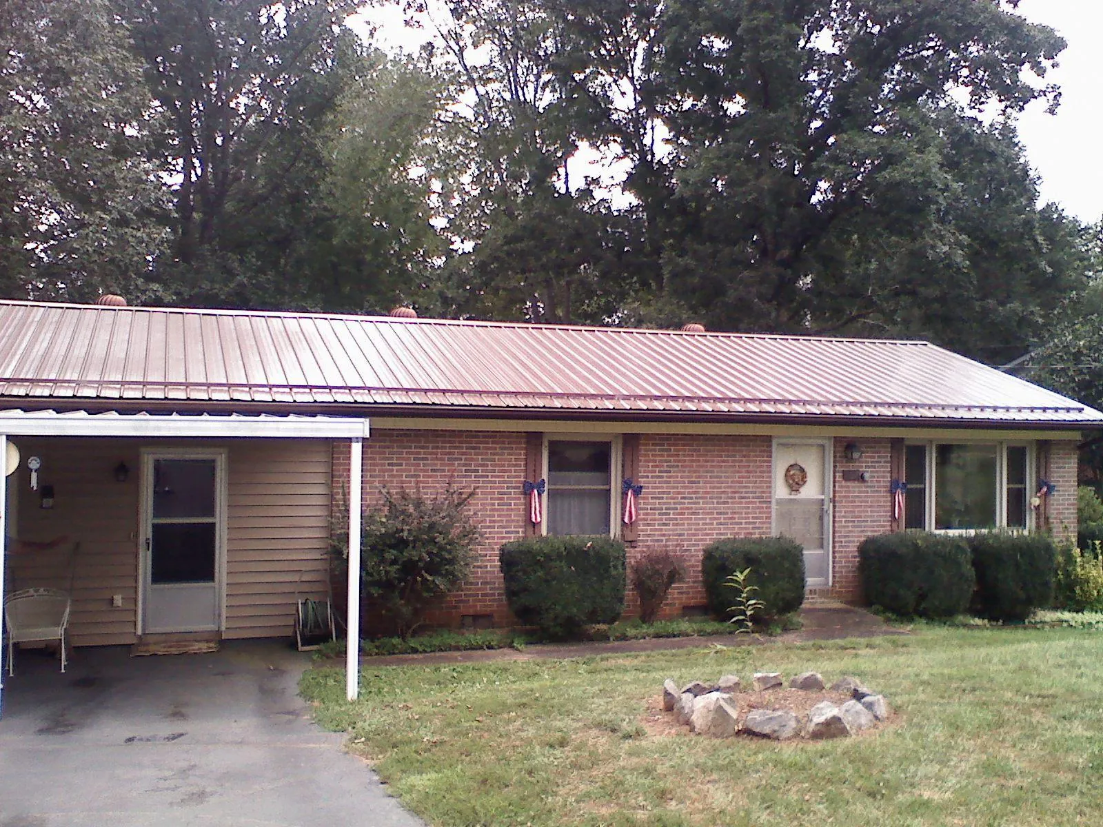 Bronze metal roof and carport on a brick ranch home — Roof Repair work by our crew in Rexburg